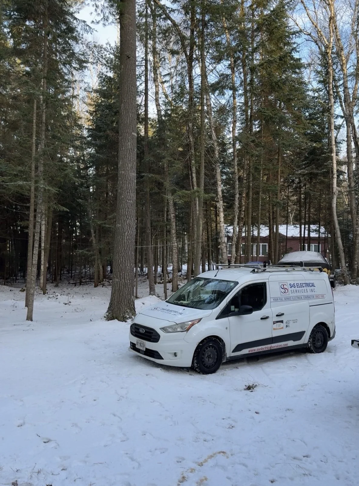 S&S Electrical Services van parked at a snowy wooded property in Huntsville.