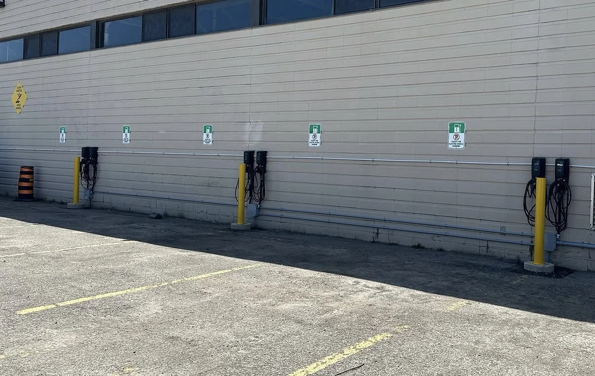 FLO EV charging stations and marked parking spaces beside an Alectra Utilities building.