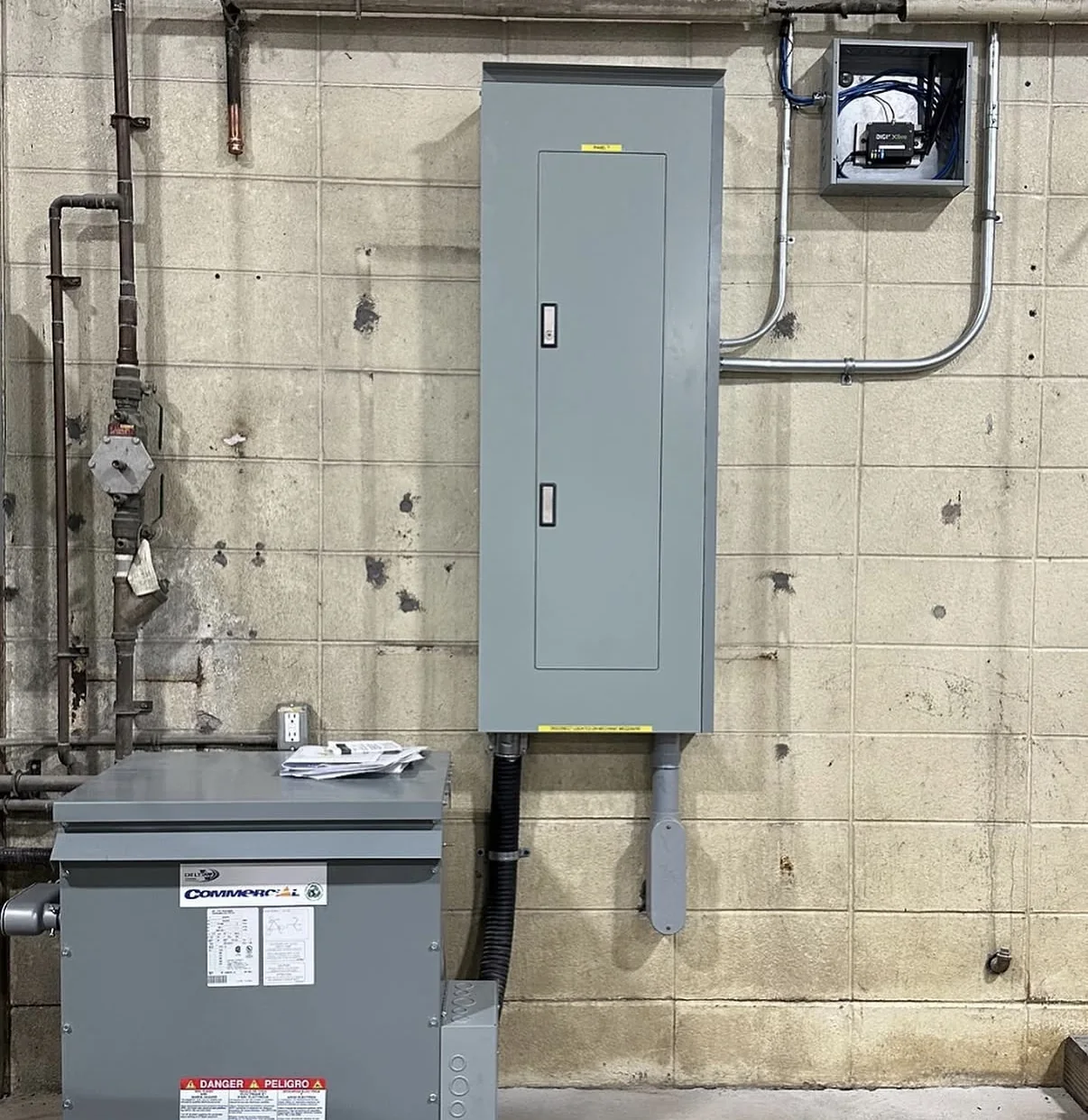 Transformer and electrical panel beside conduit and controls for a FLO charging project.