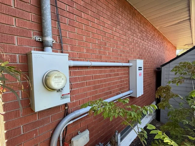 Electrical meter and conduit on brick wall