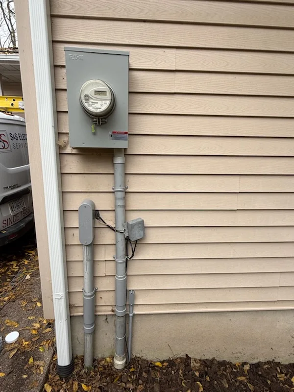 Utility meter and electrical conduit on exterior building wall