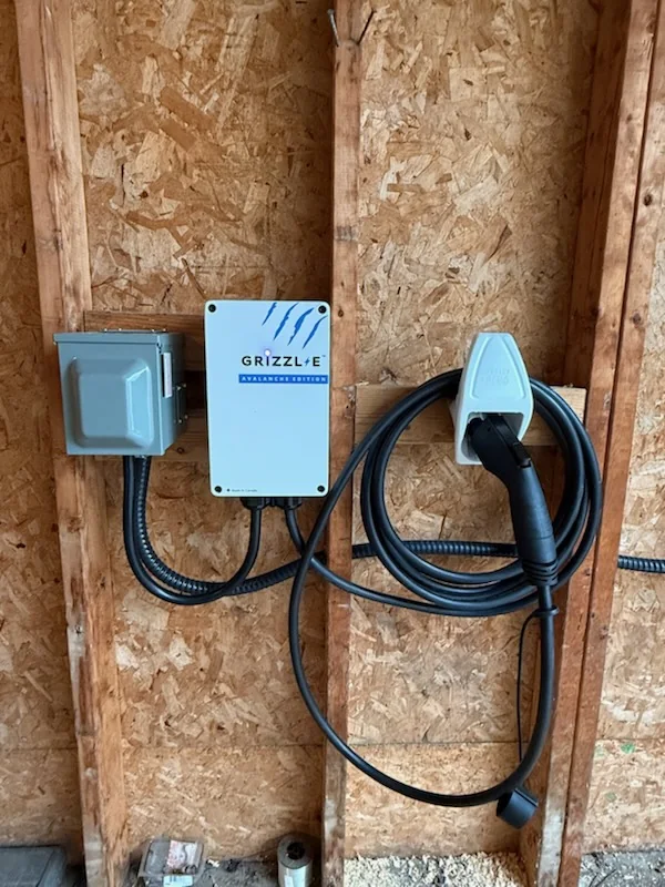 Close-up of EV charger unit with charging handle and wiring