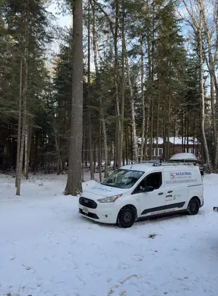 S&S Electrical Services van parked at a snowy wooded property in Huntsville.