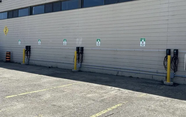 FLO EV charging stations and marked parking spaces beside an Alectra Utilities building.