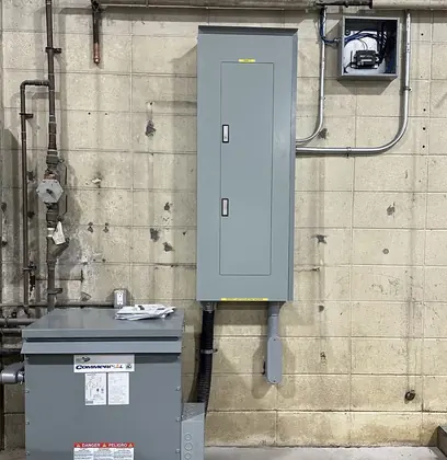 Transformer and electrical panel beside conduit and controls for a FLO charging project.