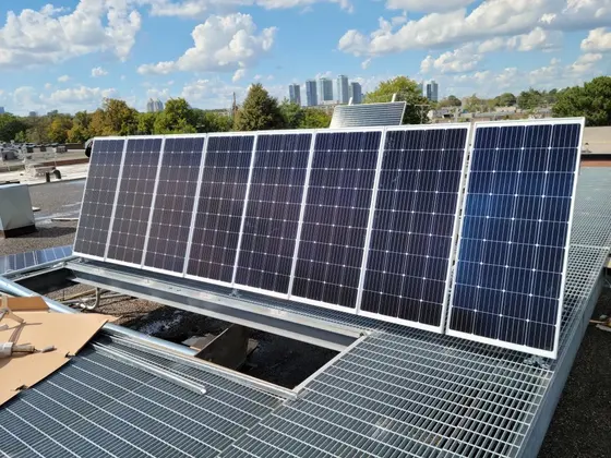 Solar panels installed on a rooftop in Toronto under a partly cloudy sky